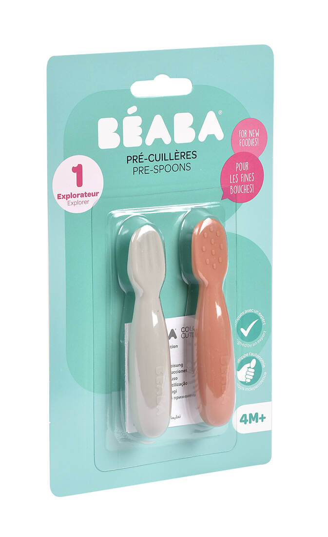 Na zdjęciu widać zestaw dwóch silikonowych łyżeczek Beaba w kolorze białym i terracotta, umieszczonych w oryginalnym opakowaniu. Produkt jest przeznaczony dla dzieci od 4. miesiąca życia i został zaprojektowany z myślą o pierwszym karmieniu.